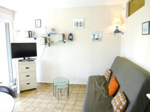 een woonkamer met een bank en een tv bij Rozenn in Sarzeau