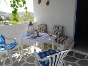 a white table and chairs in a room with a window at Loutra House Kythnos in Loutra