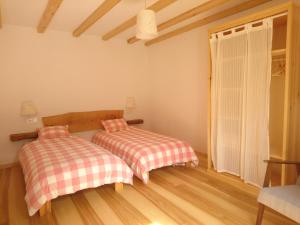 a bedroom with two beds and a window at Casa Turreta in Ansó