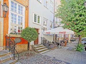 a cafe with an umbrella and chairs and a building at Apartament Starogdański 51 in Gdańsk