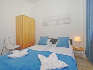 a bedroom with two beds with blue and white sheets at Apartament Starogdański 51 in Gdańsk
