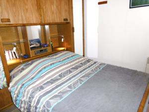 a bed with a wooden headboard in a room at Rozenn in Sarzeau