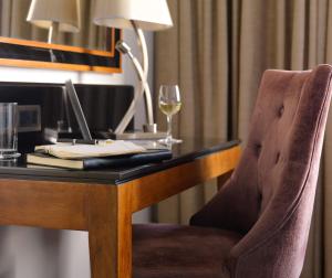 a desk with a laptop and a glass of wine at The Galmont Hotel & Spa in Galway