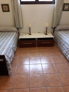 a bedroom with two beds and a tiled floor at Blue Beach in Famara