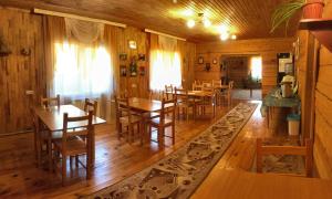 ein Esszimmer mit Holzböden sowie Holztischen und -stühlen in der Unterkunft Hotel Complex Okolitsa in Uznezya