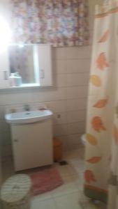 uma casa de banho com um lavatório e uma cortina de chuveiro em Aliki's House (Varres) em Zakynthos Town
