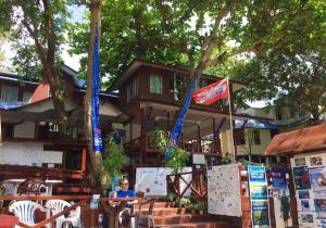 a woman standing in front of a building with flags at Quiver Dive Team Perhentian Dorm in Perhentian Islands