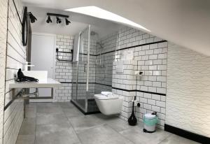 a white bathroom with a toilet and a sink at Axel Boutique Jacuzzi & Sauna in Dziwnów