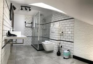a white bathroom with a toilet and a sink at Axel Boutique Jacuzzi & Sauna in Dziwnów +82 photos