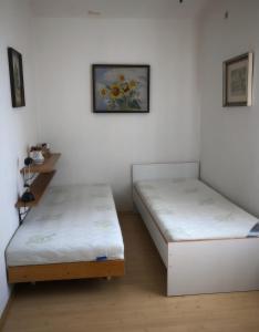 2 camas individuales en una habitación con una foto en la pared en Veliny 120, en Veliny