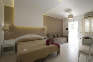 a bedroom with a bed and a couch at Garden Hotel Ripa in Vieste