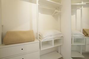 a white closet with white shelves and pillows at Garden Hotel Ripa in Vieste
