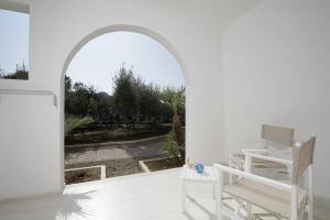 an archway with white chairs and a patio at Garden Hotel Ripa in Vieste