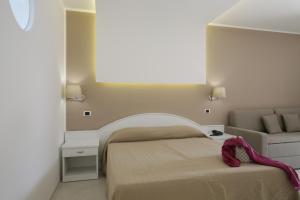 a small bedroom with a bed and a couch at Garden Hotel Ripa in Vieste