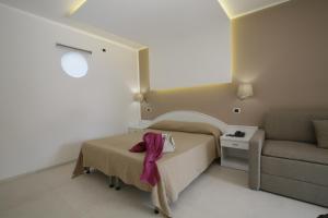 a small bedroom with a bed and a couch at Garden Hotel Ripa in Vieste