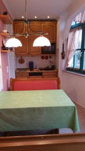 eine Küche mit einem Tisch und einem grünen Tischtuch in der Unterkunft An der Seebrücke in Boltenhagen