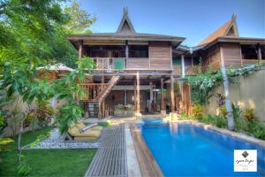 a house with a swimming pool in front of a house at Apalagi Villas in Gili Air