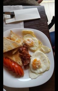 a plate of breakfast food with eggs bacon and toast at Le Petit Paris in Cluj-Napoca