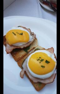 two eggs on top of toast on a white plate at Le Petit Paris in Cluj-Napoca