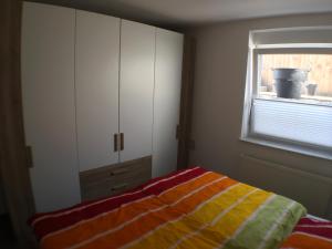 Schlafzimmer mit einem Bett und einem Fenster in der Unterkunft Ferienwohnung Alte B3 in Ringsheim