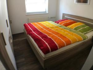 łóżko z kolorowymi kocami w pokoju w obiekcie Ferienwohnung Alte B3 w mieście Ringsheim