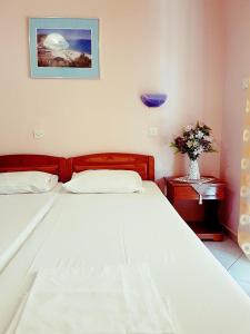a bedroom with a bed and a vase of flowers on a table at Agyra Villa in Limenaria