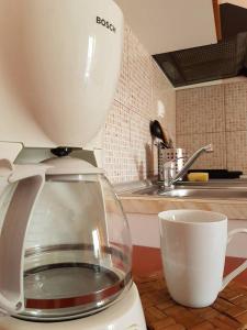 a coffee maker sitting on a counter next to a cup at Agyra Villa in Limenaria