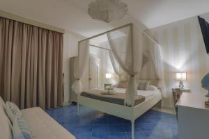 ポルト・チェザーレオにあるIl FAROのベッドルーム1室(カーテンと青いタイルのベッド1台付)