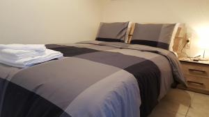 een slaapkamer met een groot bed en een nachtkastje bij Patras Port apartment in Patra