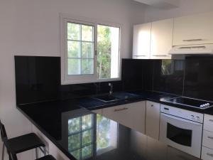 a kitchen with black counter tops and white cabinets at Vangelios Apartments in Paphos