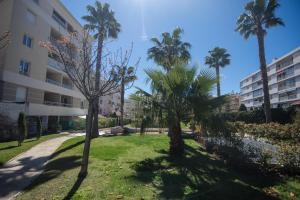 two palm trees in a park next to a building at Le Parc Pointe Croisette in Cannes