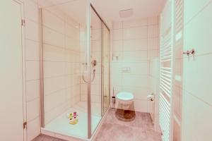 マルクドルフにあるFeWo City Appartement 2のシャワーとトイレ付きの白いバスルーム +6枚の写真