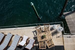 - une vue aérienne sur une terrasse avec des chaises et l'eau dans l'établissement Darsena di Riva Grande, à Moltrasio