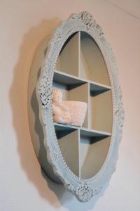 a mirror with a baby sitting on a shelf at Studio Confort, en face du campus 1 et du tramway in Caen