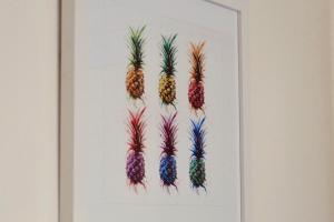 a picture of four pineapples hanging on a wall at La Company Des Concierges : Le Galion in Caen