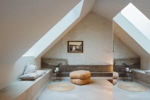 a loft conversion with a staircase and a couch and stool at Hotel Pilar in Antwerp