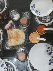 a table topped with plates and bowls of food at Angelann Homestay in Cochin