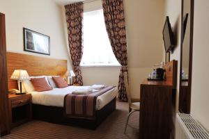 Habitación de hotel con cama y ventana en Alexander Thomson, en Glasgow