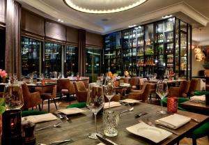 a dining room with tables and chairs with wine glasses at Hotel de Leijhof Oisterwijk in Oisterwijk