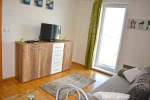 a living room with a tv on top of a dresser at Apartman De Luxe in Donovaly