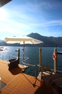 un parasol blanc assis sur le pont d'un bateau dans l'établissement Darsena di Riva Grande, à Moltrasio