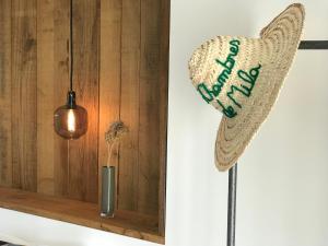 a hat hanging on a wall next to a vase at Hotel Les Chambres de Mila in Bonifacio