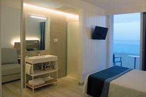 a bathroom with a bed and a sink and a mirror at Rocatel in Canet de Mar