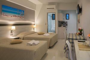 um quarto de hotel com duas camas e uma cozinha em Irene Studios em Mastihari