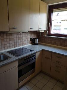 a kitchen with a stove and a sink and a window at AB Apartment Objekt 26 in Stuttgart