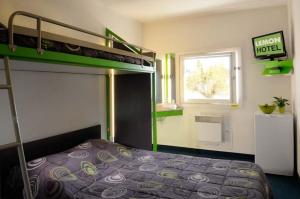 Dormitorio pequeño con litera y ventana en Lemon Hotel en Le Coteau