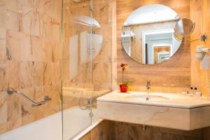um banheiro com uma pia, um chuveiro e um espelho em Hotel Pestana Cascais Ocean & Conference Aparthotel em Cascais