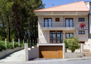 dom z garażem przed nim w obiekcie Sanxenxorural - Apartamentos La Rana w mieście Sanxenxo