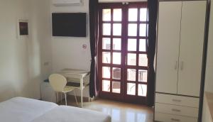 um quarto com uma cama, uma secretária e uma janela em Old Town & Sea View em Dubrovnik