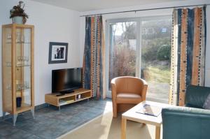 a living room with a couch and a tv at Ferienwohnungen Haus am Deich in Prerow